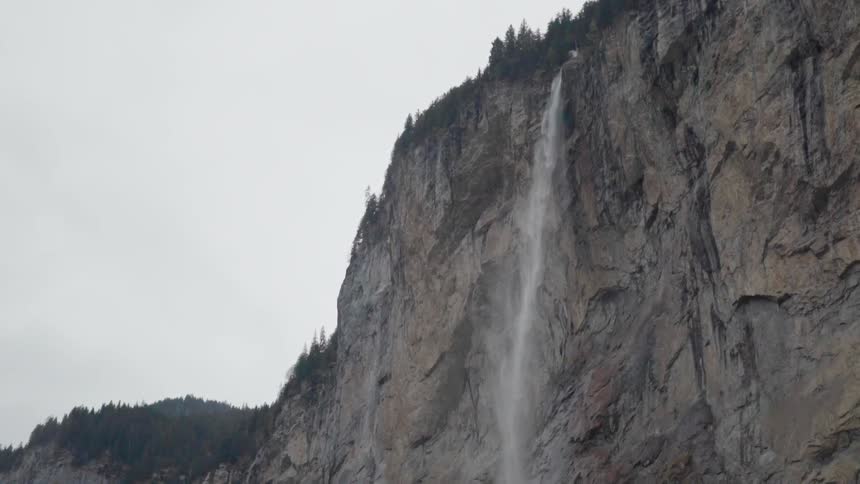 The waterfall is pouring off the top of the mountain