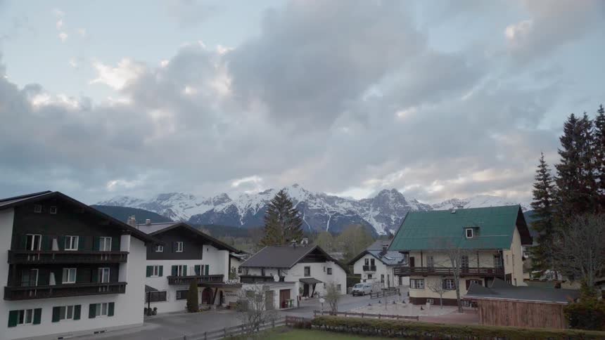 Buildings in a village sit under a cloudy blue sky