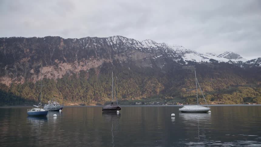 Sailboats are anchored in a mountain lake