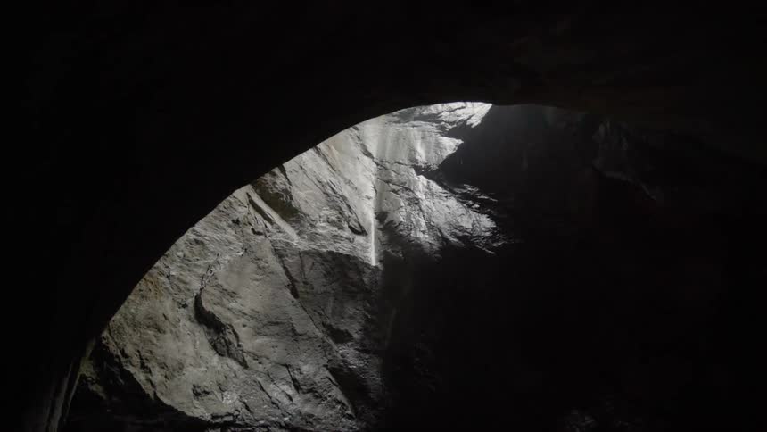 The sun shines through an opening in the rocks