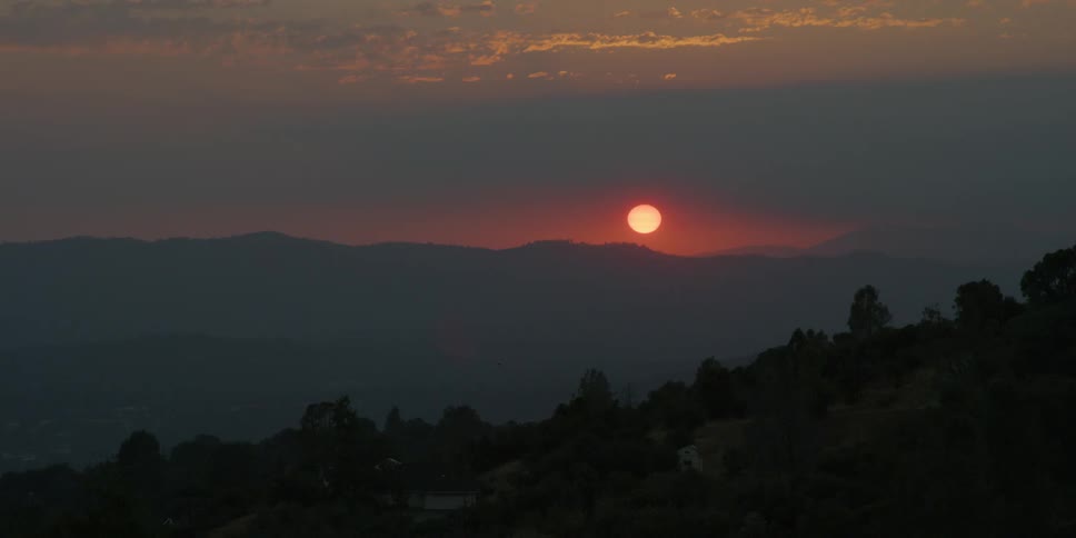 The sun sets over mountains