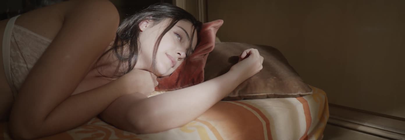 A woman is laying in bed smiling