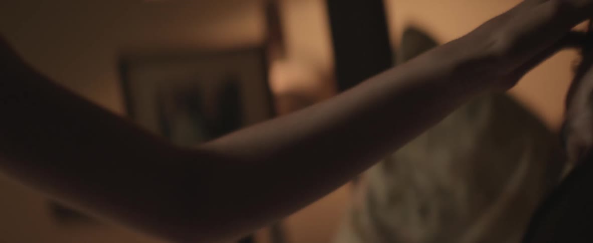 A woman plays with her husbands hair and he reaches out to touch her face