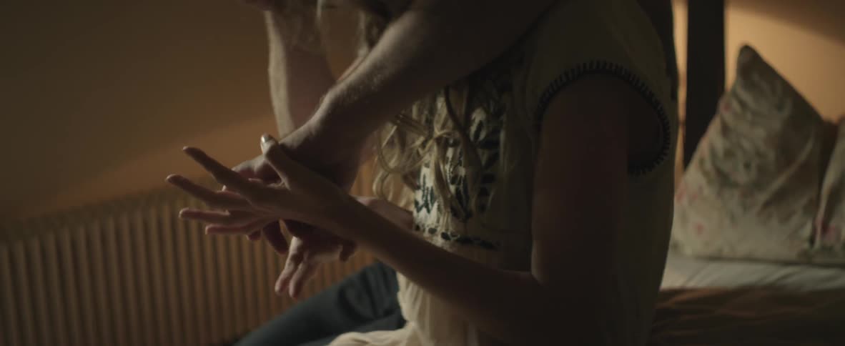 Man and woman sitting on a bed together