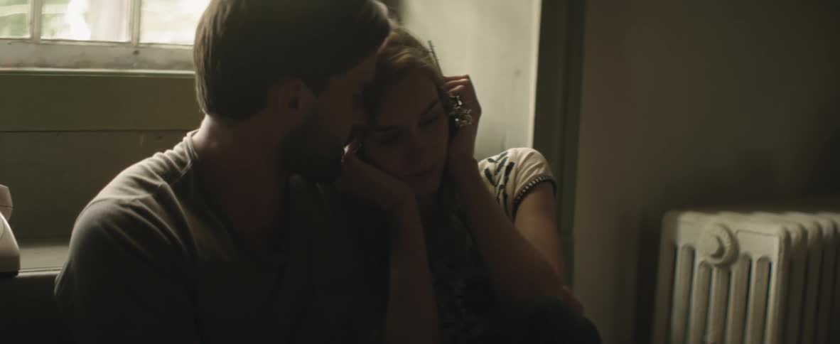 Man holds a woman by a window