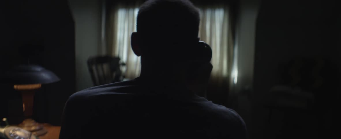 Man talking on a phone in a dark room
