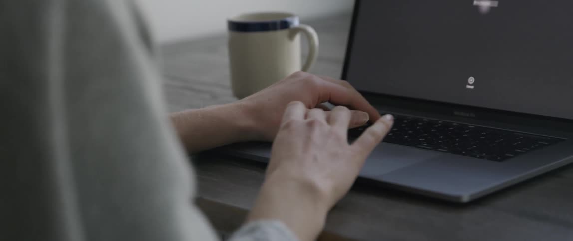 A woman uses a laptop on a table