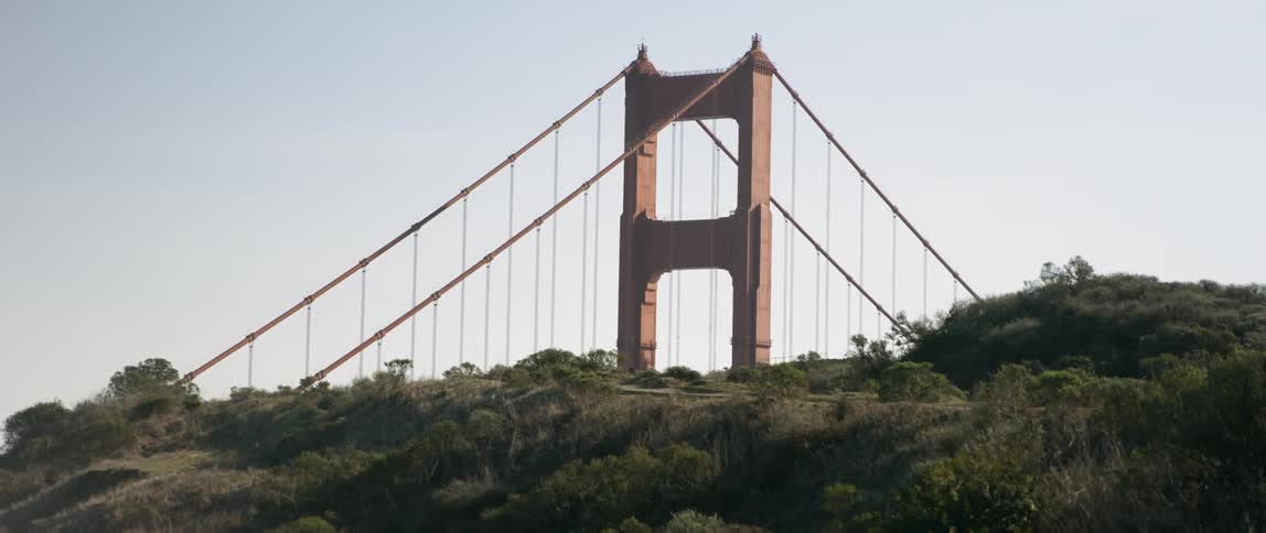 A tall bridge is behind the hills