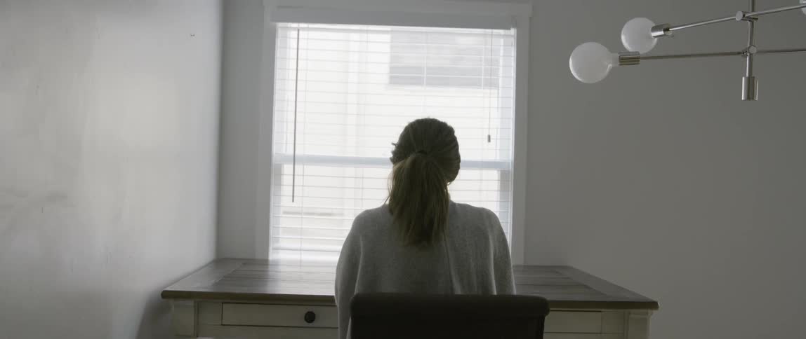 Woman drinks coffee at a desk