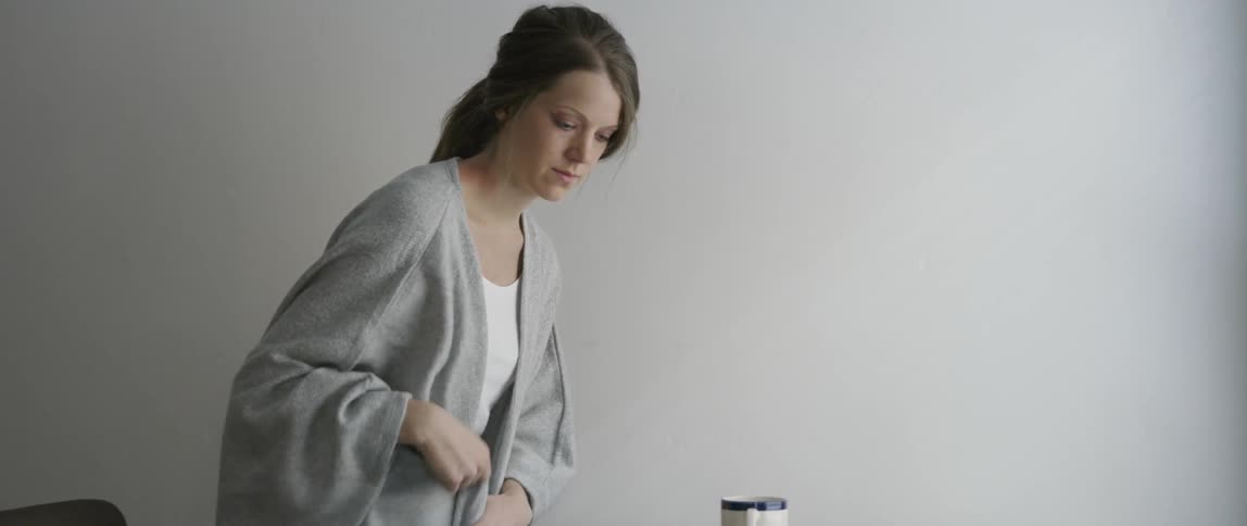 A woman sits down to use her laptop with a drink