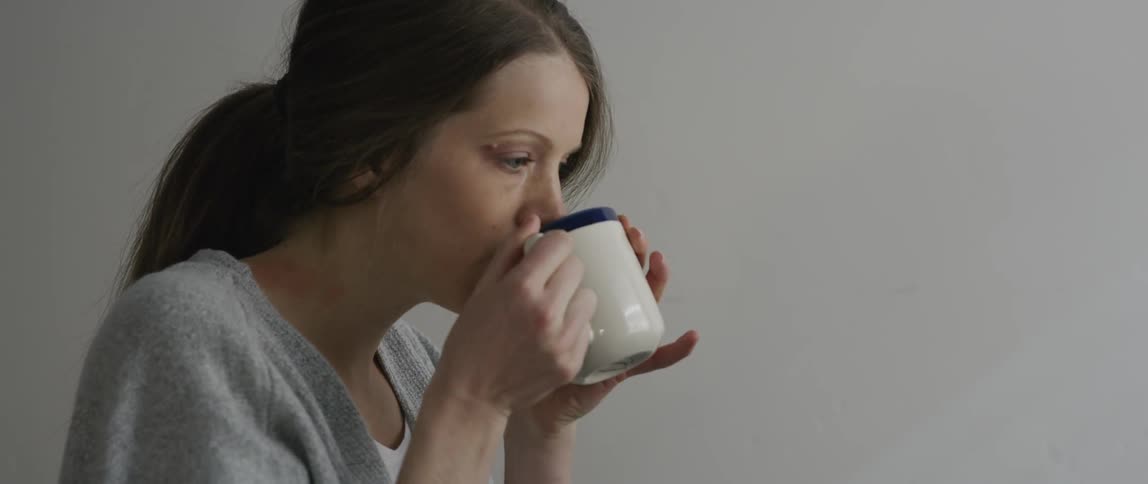 A woman takes a sip from a mug