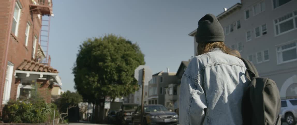 Woman walks on a city sidewalk