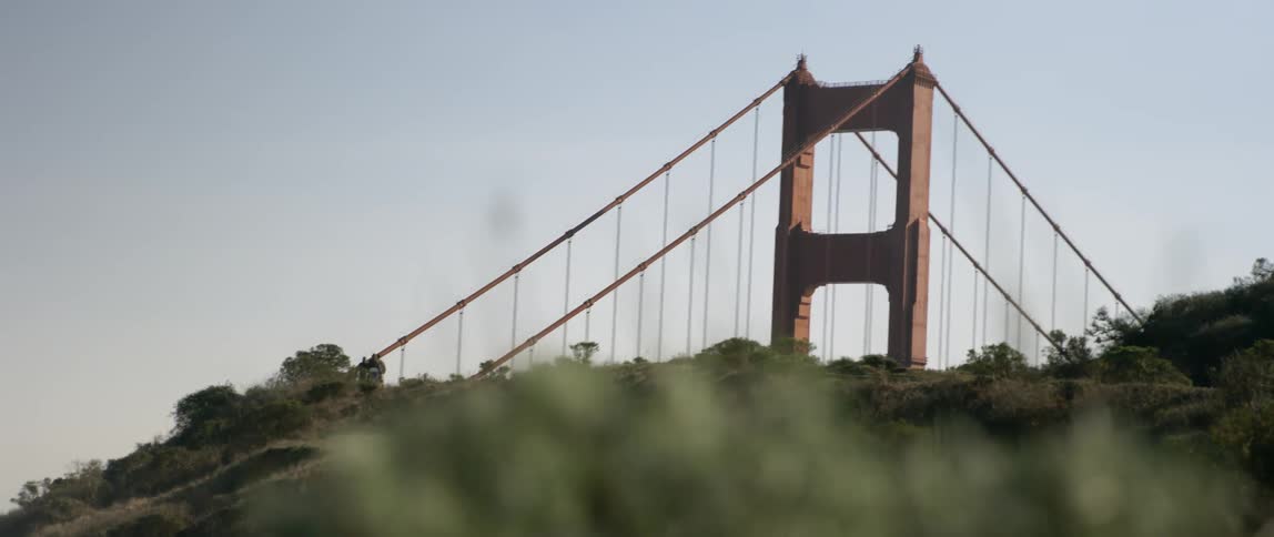 People walk along a ridge near the golden gate bridge
