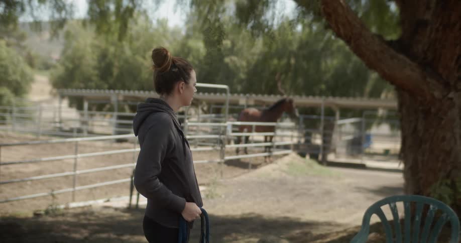 Woman stands in a pen on a farm