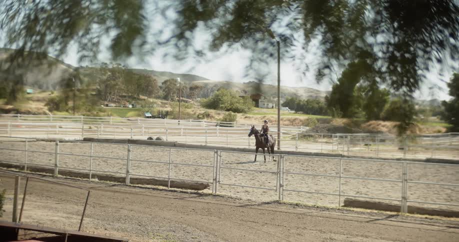 A person is riding their horse behind the fence