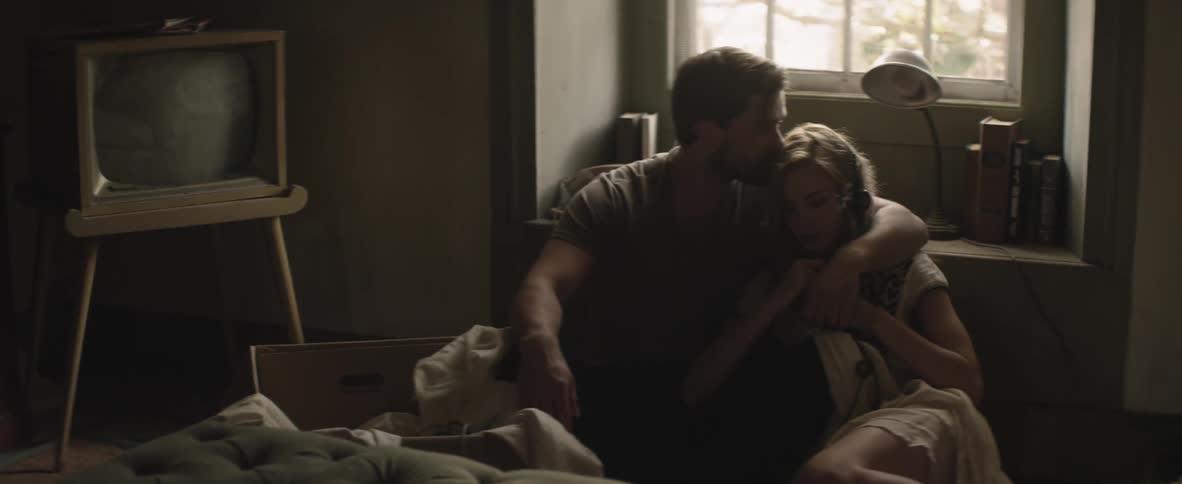 A man and woman cuddling on the floor