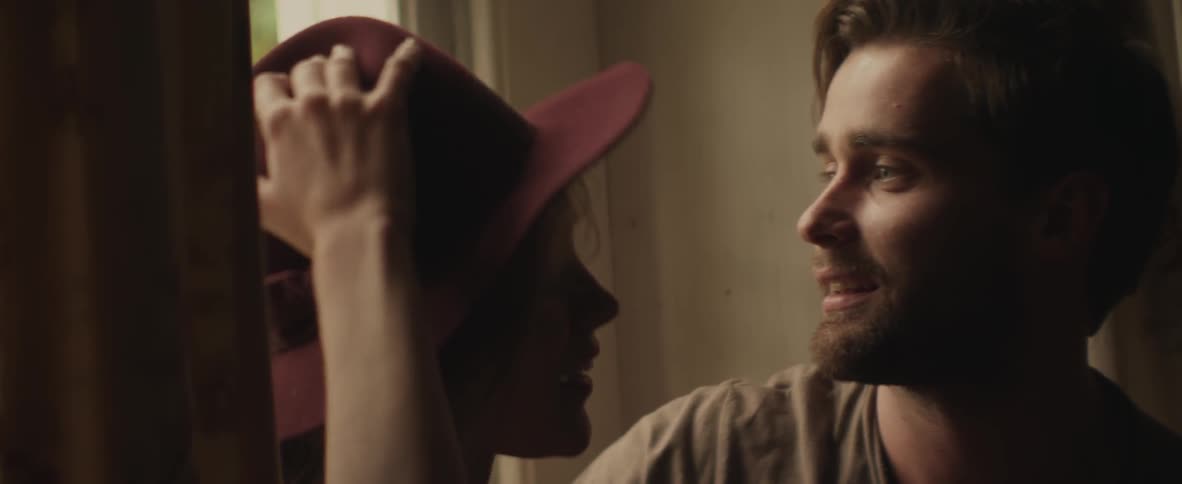 Man adjusts hat on a woman