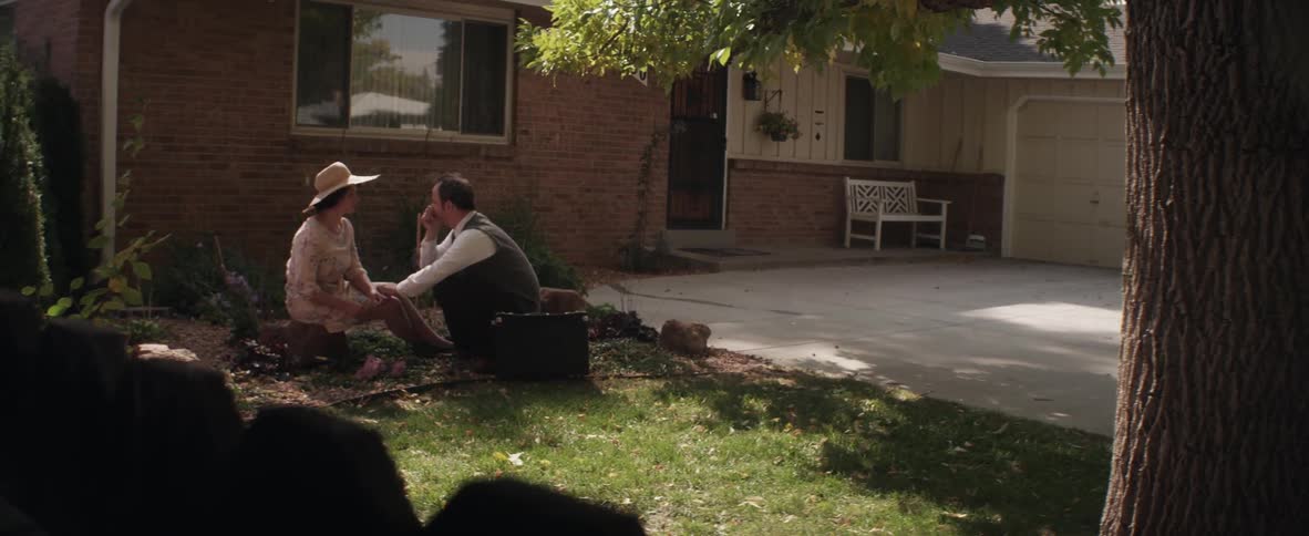 A man and woman sitting in a garden having a conversation