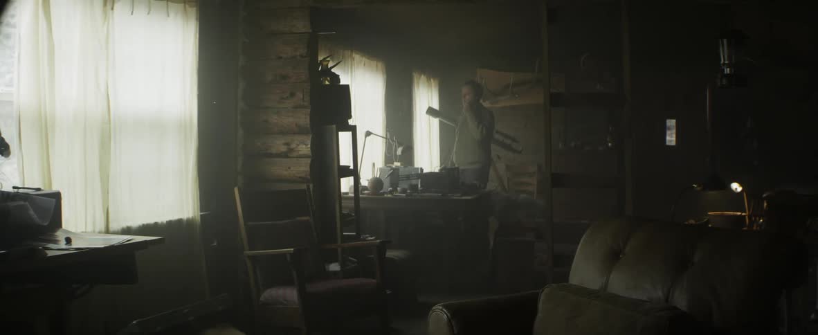 Man in inside the house talking on the phone next to his dog