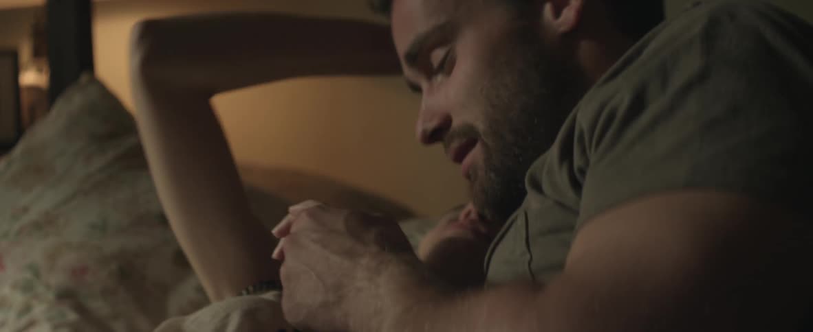 Man and woman laying in bed talking and cuddling