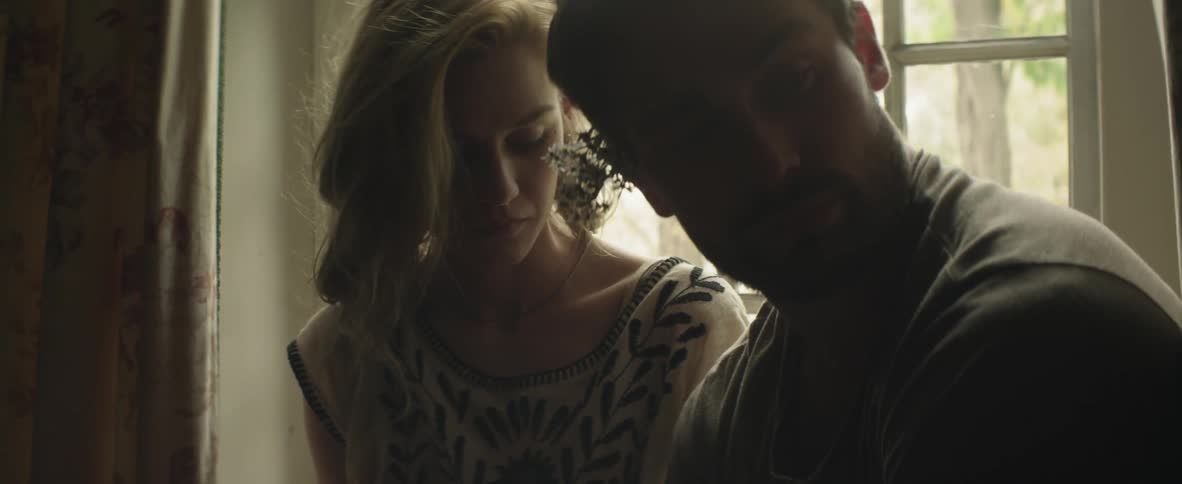 Man and woman sit on a windowsill together
