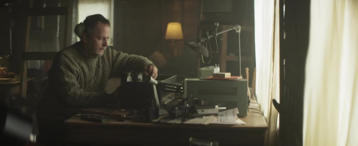 Man sitting at a desk repairing equipment