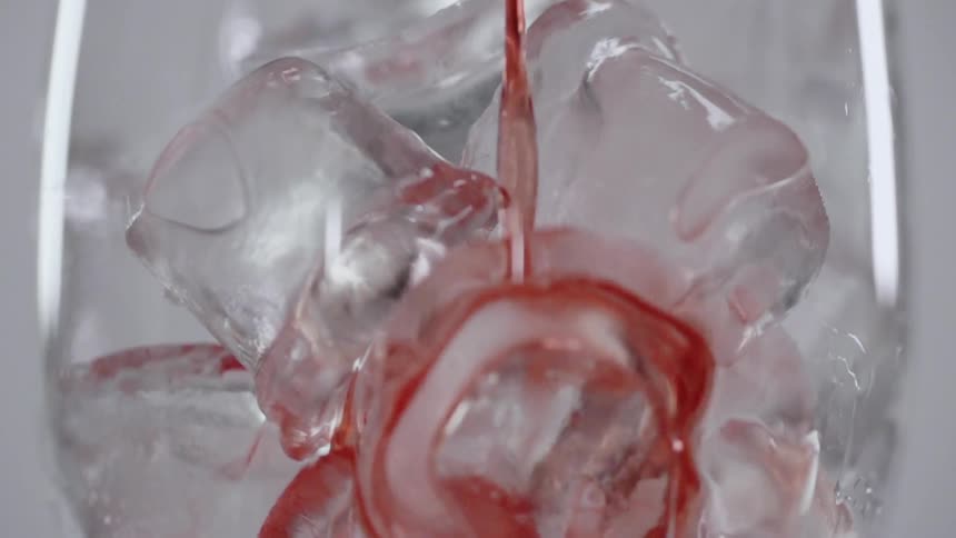 The glass full of ice is filled with a beverage