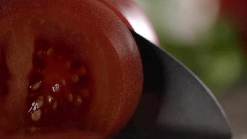 A tomato is cut into slices