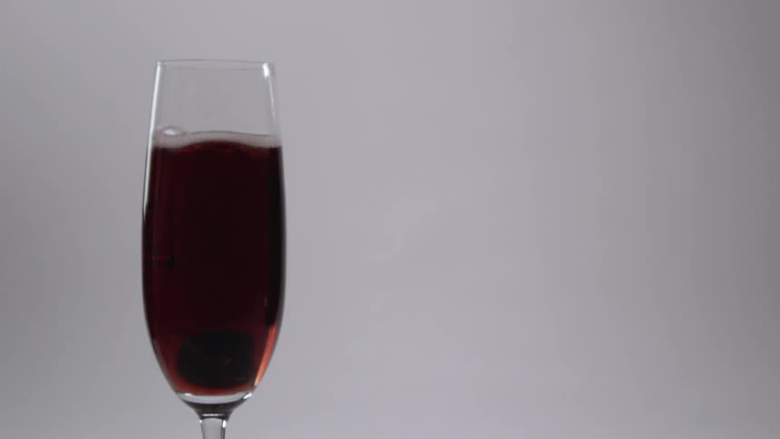 A piece of fruit is dropped into the glass