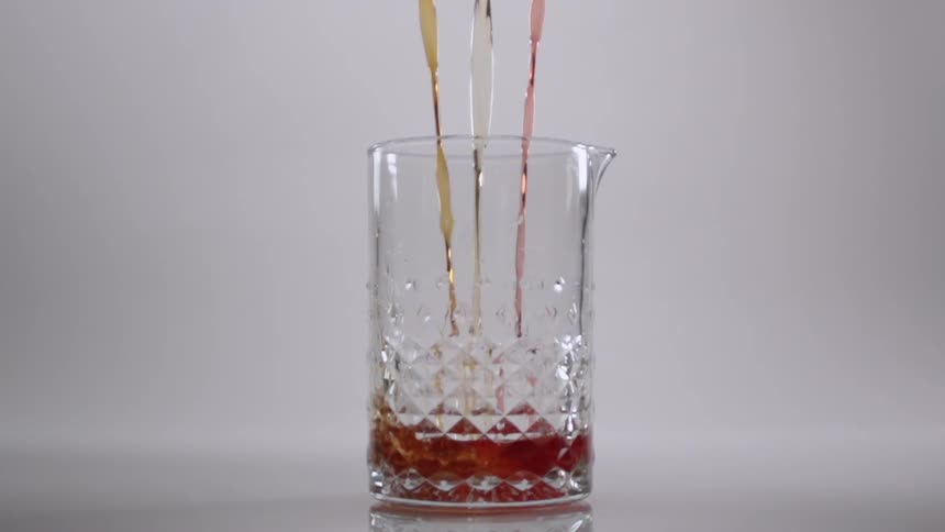 A drink is poured into a tall glass
