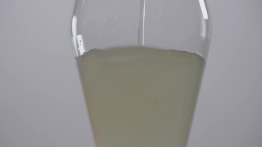 A beverage is poured into a glass