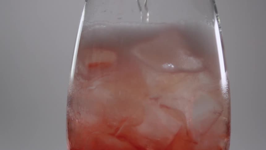 The glass is being filled with liquid