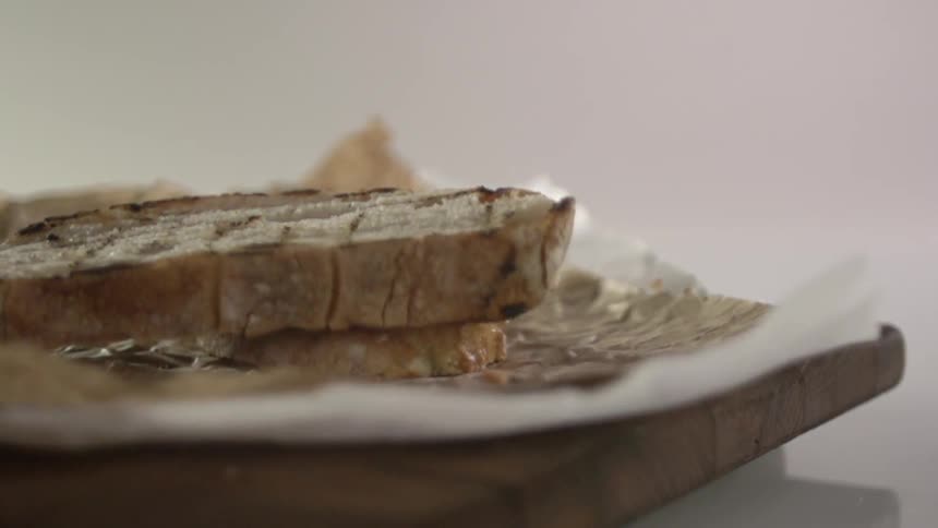 Bread being dropped on a plate