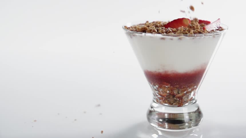A small glass is being filled with food