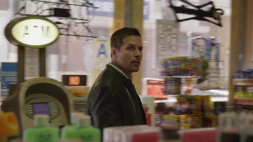 Man enters a store and walks towards the back