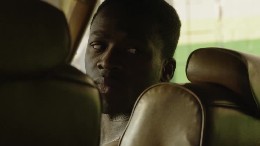 A man sits in the passenger seat of a car