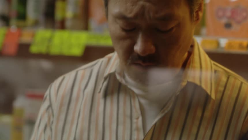 A cashier counts money behind the counter