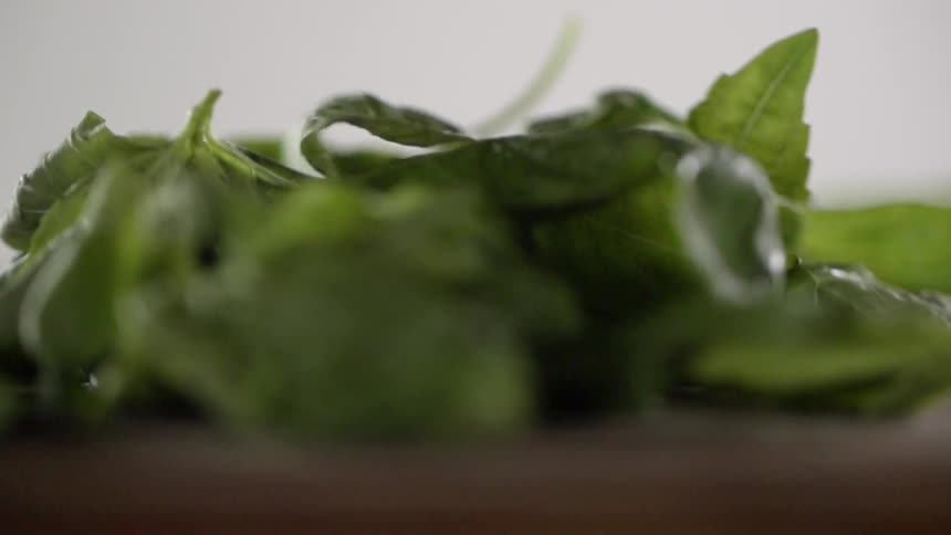 Green leaf spinach falls onto a counter top