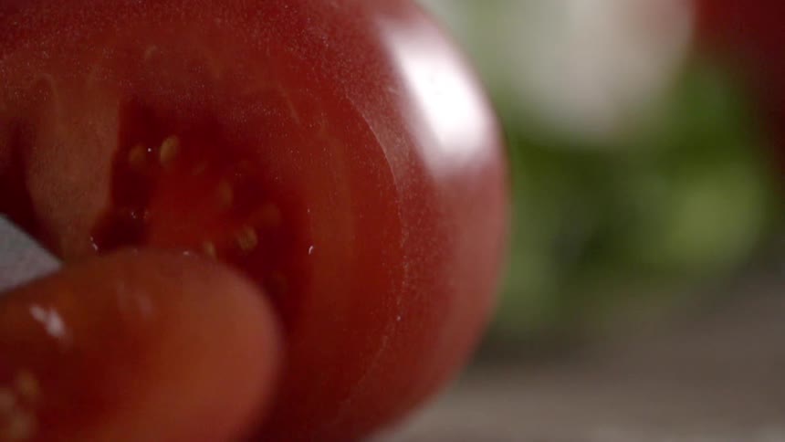 A person is slicing up a tomato