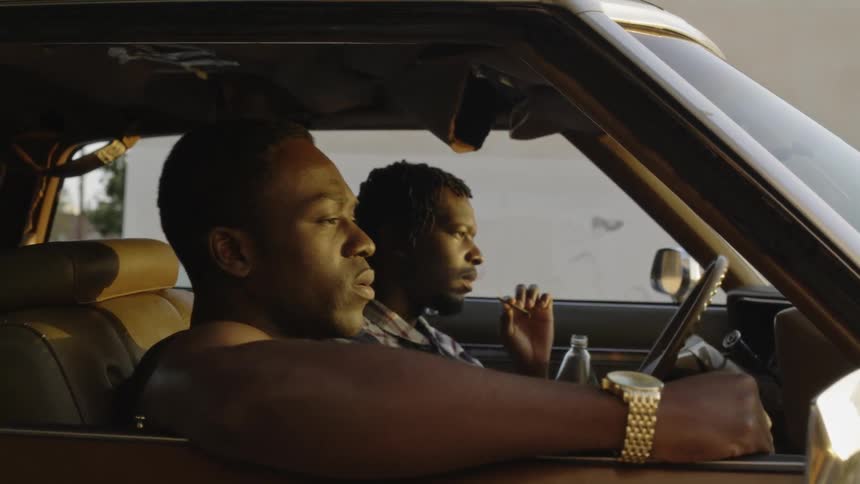 Men sit and smoke in a parked car