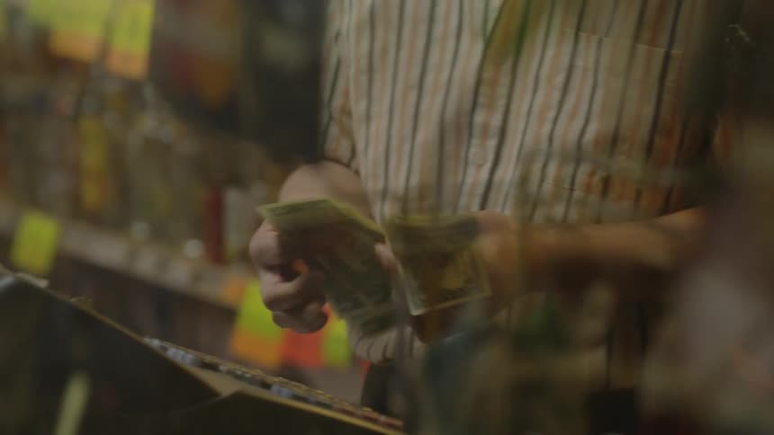 A man is counting out money from a register