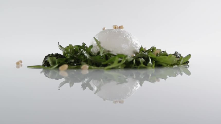 Raisins drop onto a mound of cottage cheese surrounded by lettuce