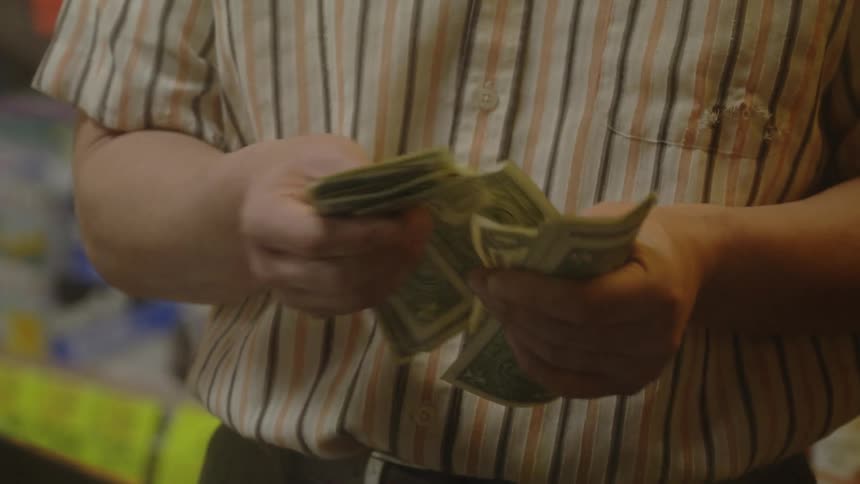 A man counts and heads one dollar bills