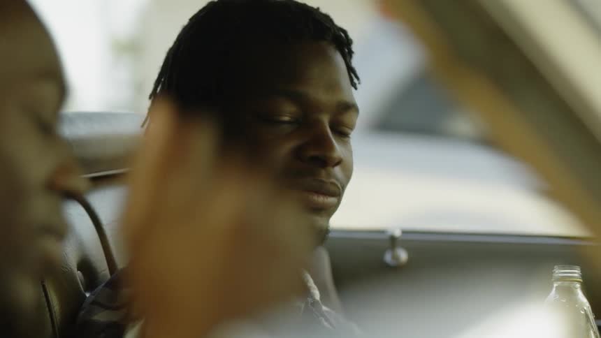 A man sits in his vehicle talking with someone