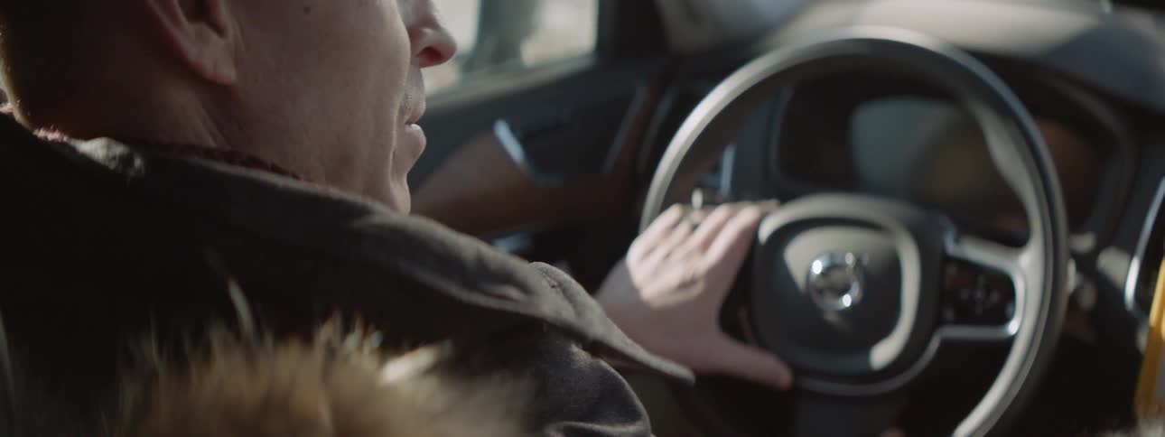 A man smiles as he drives the car