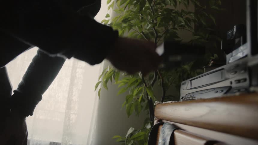 A man removes a vcr tape from the machine