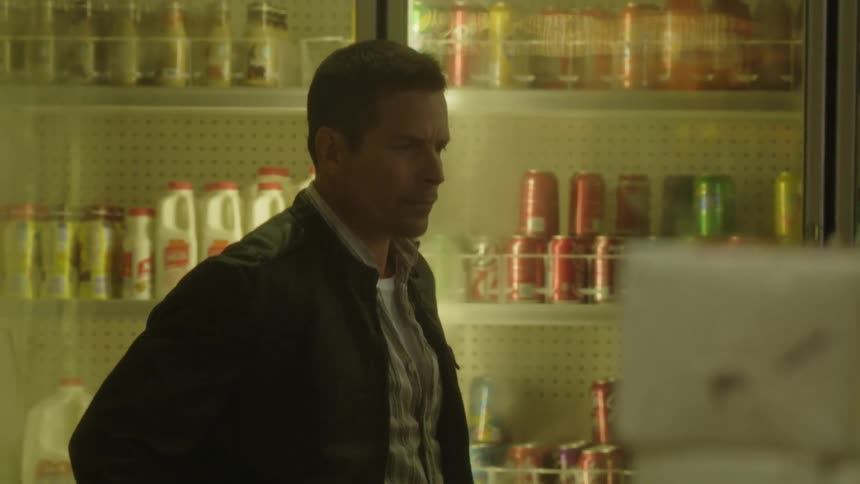 A man in a store looks at items on a shelf