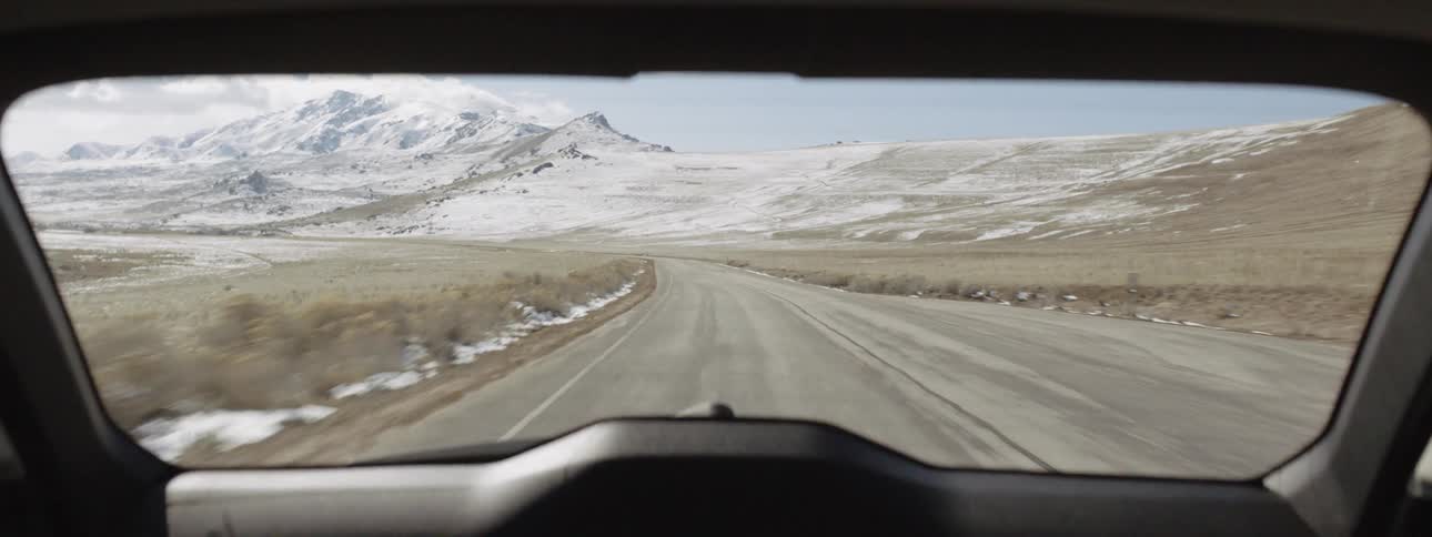 A car drives near snowy mountains