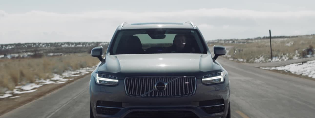 The silver car drives down the road