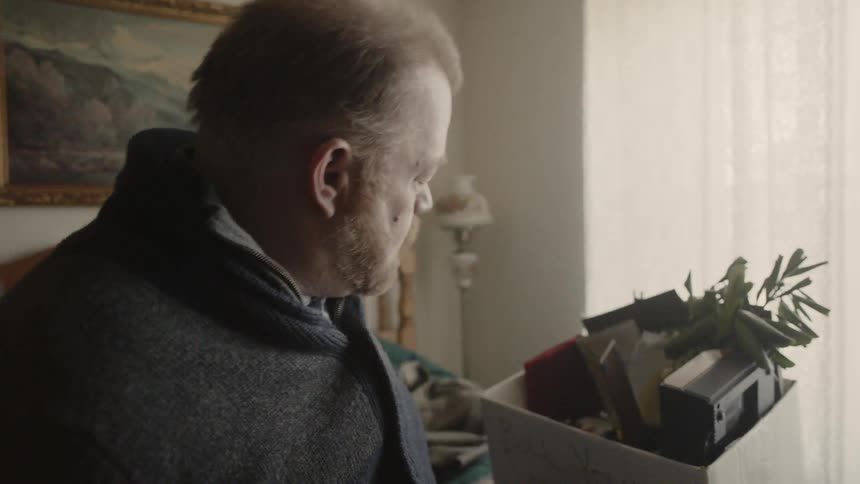 A man unpacks a box of belongings